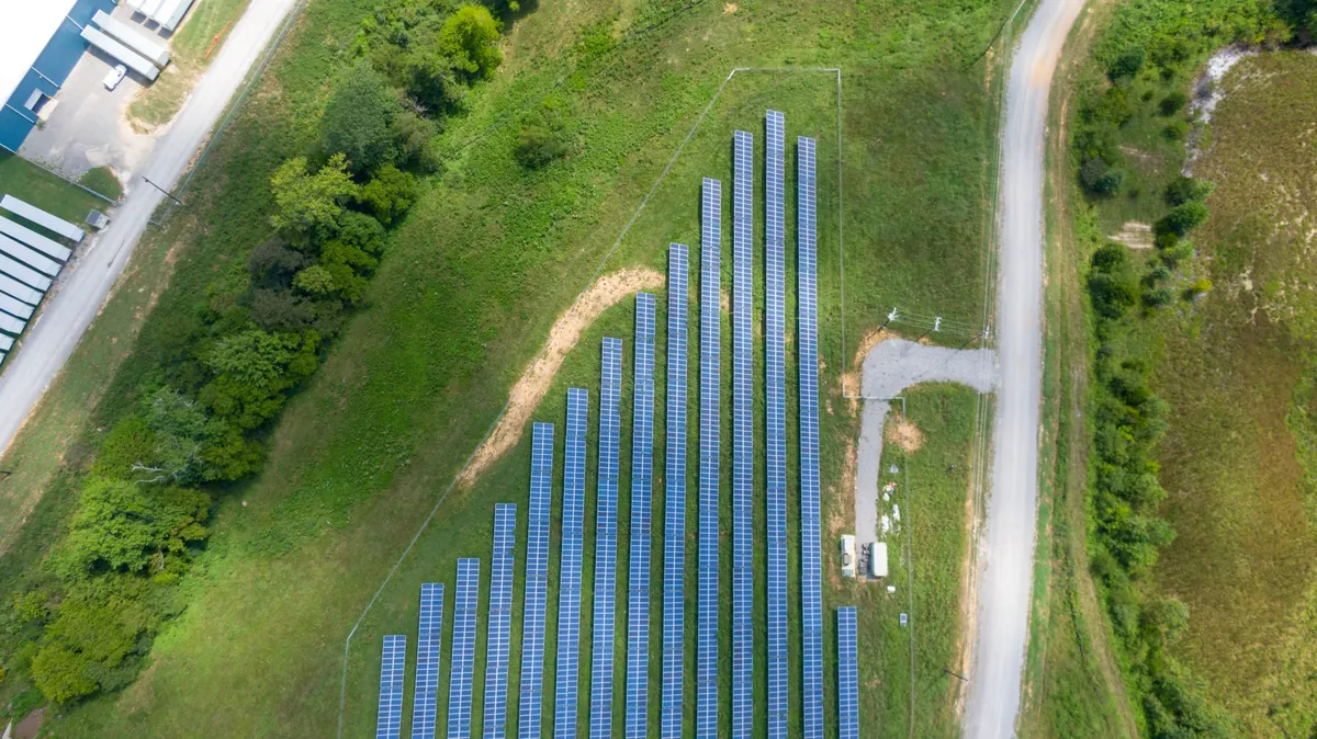 Aerial view of a solar panel array set in a green field